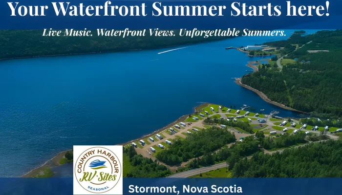 Aerial view of a waterfront RV park by a lake, surrounded by forests, with boats on the water and campsites along the shore in Stormont, Nova Scotia.